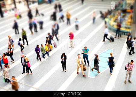 Une longue promenade de banlieue pour les piétons mais centré sur une femme à l'aide de son mobile que tout le monde se précipite par. Tourné en mode miniature Banque D'Images