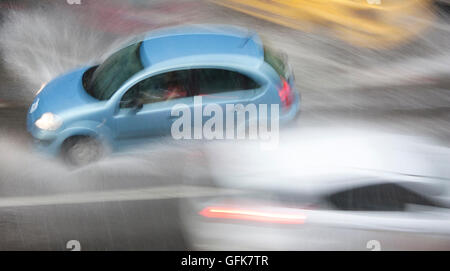 Conduire des voitures dans la rue ville touchée par les fortes pluies de grêle en situation dangereuse avec une faible visibilité Banque D'Images