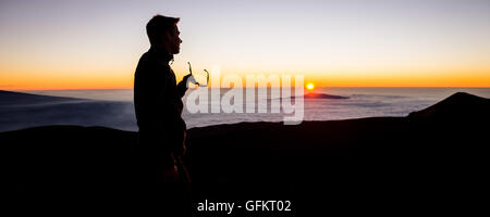 Personne de sexe masculin en lunettes de soleil pour regarder le haut de la montagne volcan Mauna Kea sur Big Island, Hawaii Banque D'Images