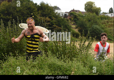 Hakon Stokka Frahm, de la Norvège, traverse la grande ortie habillé comme une abeille au cours de l'ortie Tough Guy Warrior 2016 à South tonne Farm dans le Staffordshire. Banque D'Images