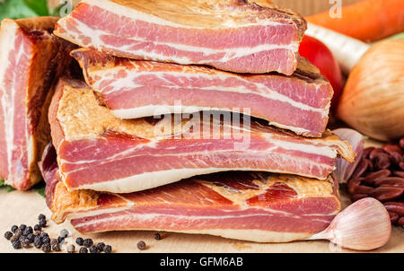 Pile de côtes de porc fumé avec haricots rouges secs et de légumes sur une planche en bois Banque D'Images