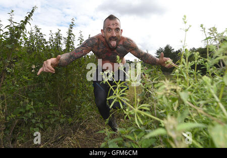 Un concurrent traverse la grande ortie Ortie Warrior Tough Guy pendant 2016 à South tonne Farm dans le Staffordshire. Banque D'Images