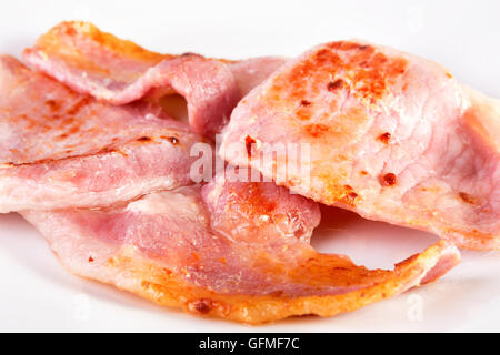 Les tranches de bacon frit sur une plaque blanche. SDOF Banque D'Images
