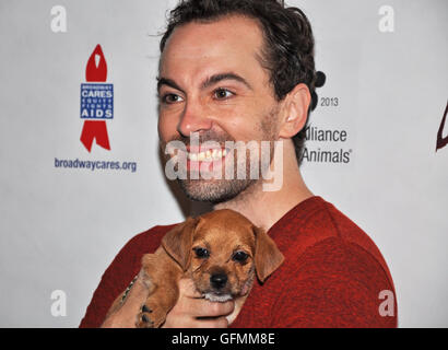 Shubert Alley, New York, New York. 30 juillet, 2016. Rob Mclure, star de "quelque chose de pourri," ne peut pas résister à un adorable chiot, un des nombreux en adoption à l'événement de l'écorce de Broadway hier dans le quartier des théâtres. Banque D'Images