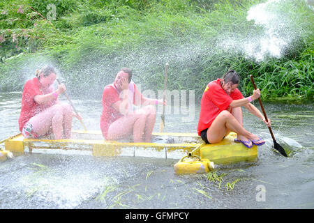 Jeux de plaine, Thorney, Somerset, Royaume-Uni. 31 juillet, 2016. Les concurrents participent à la course annuelle des Jeux de plaine Raft sur la rivière Parrett dans le Somerset. Des centaines s'est avéré dans la chaleur pour regarder les Jeux de plaine qui comprend des événements tels que les balles de foin Course, femme, portant sa rivière un Knock Out, la lutte, la boue et Chunder Défi. Les jeux, a commencé en 1984, ont lieu chaque année dans le village de plaine inondée de Thorney qui est devenu pour la première fois depuis des siècles durant le Somerset inondations en janvier 2014 Crédit : Tom Jura/Alamy Live News Banque D'Images