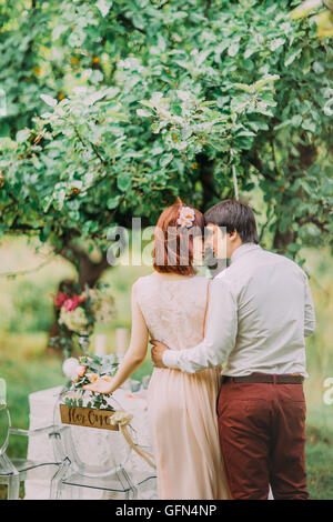 Bride and Groom posing at table de banquet décoré dans le parc d'été. Profitez de moment de bonheur Banque D'Images