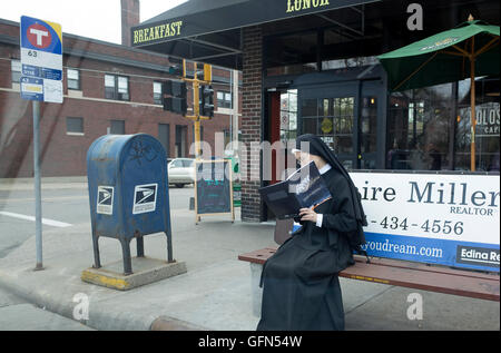 Nun de son habit assis sur un banc à l'arrêt de bus 4e année lecture brochure catholique espère et craintes. St Paul Minnesota MN USA Banque D'Images