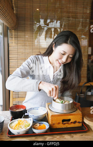 Belle jeune femme japonaise manger au restaurant Banque D'Images