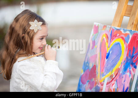 Peu d'artiste créant une peinture et d'avoir un grand temps à l'extérieur Banque D'Images