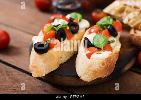 Bruschetta à la tomate, mozzarella, Pesto au basilic et olives Banque D'Images