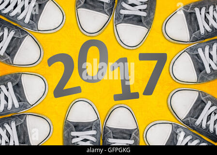 Bonne année concept, jeunes gens portant des chaussures de dessus entourant nombre 2017 Banque D'Images