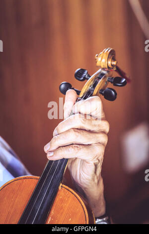 Vieil homme (luthier) à jouer du violon avec de mains Banque D'Images