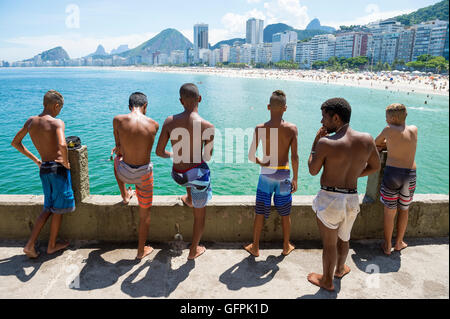 RIO DE JANEIRO - le 27 février 2016 : les jeunes Brésiliens se rassemblent pour plonger à partir de la corniche à Copacabana, à l'extrémité de la plage de Copacabana. Banque D'Images