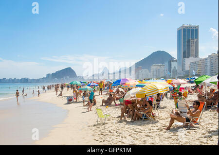 RIO DE JANEIRO - février 27, 2016 : la foule des amateurs de remplir la plage de Copacabana avec parasols colorés sur un bel après-midi. Banque D'Images