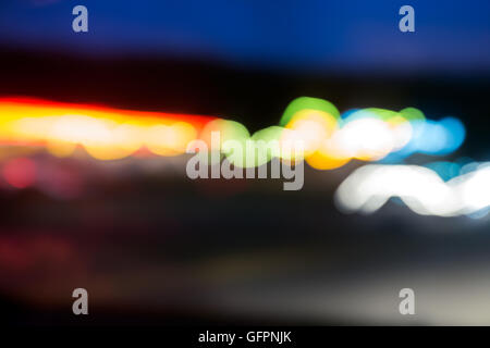 La circulation dans la nuit de flou artistique vu à travers un pare-brise de voiture Banque D'Images