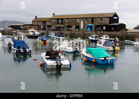 La pêche et les bateaux de plaisance amarrés dans l'abri de la Cobb, Lyme Regis, dans le Dorset, UK sur un ciel nuageux jour Juin Banque D'Images