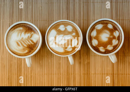 Trois tasses de café latte avec trois formes de latte art Banque D'Images