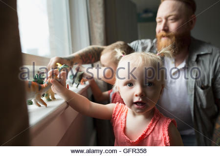 Père et fille Portrait Playing with toy dinosaures à rebord