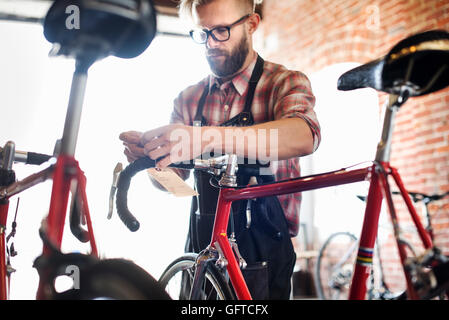 Un homme travaillant dans un atelier de réparation de vélos Banque D'Images