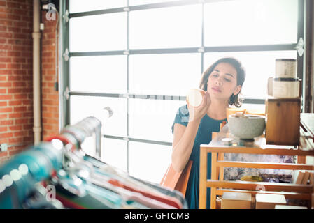 Jeune femme dans un magasin à la tasse en céramique à un Banque D'Images