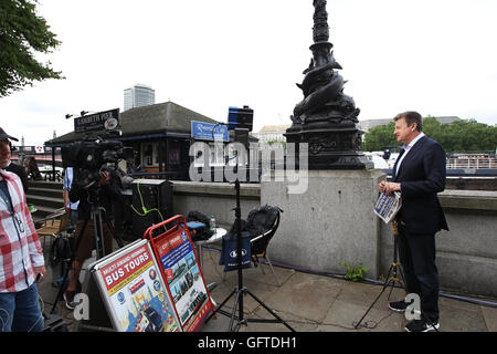 Un journaliste de faire une émission en direct de parler de l'Brexit résultats sur les rives de la Tamise Banque D'Images