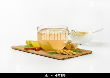 Tasse de thé au gingembre avec le citron, le gingembre et la cannelle sur planche à découper en bois Banque D'Images