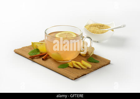 Tasse de thé au gingembre avec le citron, le gingembre et la cannelle sur planche à découper en bois Banque D'Images