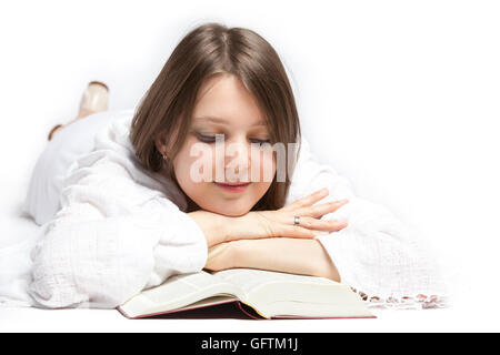 Jeune femme couchée sur un étage et la lecture de la Bible. Isolé sur fond blanc Banque D'Images