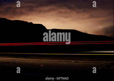 Sentiers des projecteurs avec des montagnes se profilant au soleil. Banque D'Images