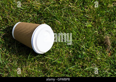 Papier non recyclables tasse de café allongé à l'abandon sur l'herbe Banque D'Images