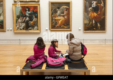 Galerie d'art d'enfants, une mère et ses deux filles voir l'art du 17ème siècle dans les peintures du musée du Louvre à Paris, France. Banque D'Images