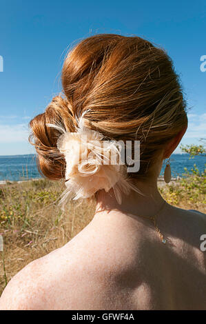 Une femme aux cheveux rouges de derrière donnant sur une baie. Banque D'Images