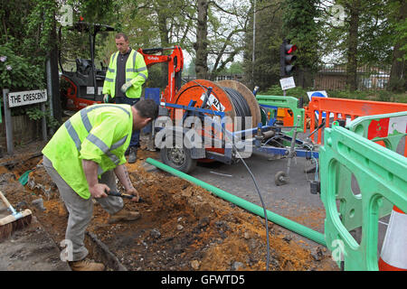 Ouvriers jeter de nouveaux câbles à fibre optique pour la haute vitesse à large bande dans une zone rurale de Kent, UK Banque D'Images