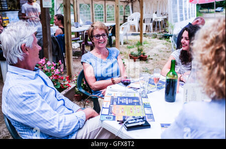 Famille et amis aiment manger à l'extérieur repas au restaurant Le Lot et Dordogne, France Juillet 2016 Banque D'Images