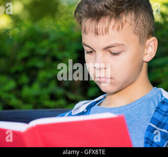 Teen boy reading book Banque D'Images