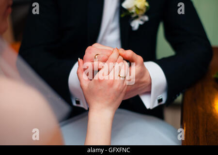 Mains de wedding couple mettre anneaux dorés à doigt de l'autre. Banque D'Images