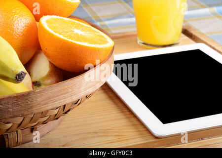 Fruits frais et un Tablet PC sur table en bois. Concept de saine alimentation