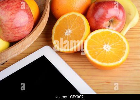Fruits frais et un Tablet PC sur table en bois. Concept de saine alimentation