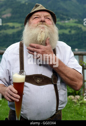 Hotel Gasthof Brüggler Fritz homme barbu en pantalons de cuir et une chemise traditionnelle dans son jardin haut au-dessus de la ville de Zell am See en Autriche le 15 juin 2016. Avec sa barbe Garibaldi il a été vice-Champion d'Europe, Champion du Monde et même barbe Olympia gagnant. Le 06 août 2016, il sera à la 2ème du championnat autrichien internationale des barbus dans le cadre de la 34e fête du village à Dorfgastein. En 2012, il a été attribué pour la plus belle barbe Garibaldi de l'univers. Hotel Gasthof Brüggler Fritz dirige son propre petit musée de couture avec plus de 2500 machines à coudre et de 1000 verres et il prépare sa Banque D'Images