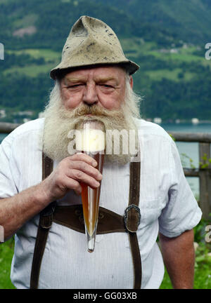 Hotel Gasthof Brüggler Fritz homme barbu en pantalons de cuir et une chemise traditionnelle dans son jardin haut au-dessus de la ville de Zell am See en Autriche le 15 juin 2016. Avec sa barbe Garibaldi il a été vice-Champion d'Europe, Champion du Monde et même barbe Olympia gagnant. Le 06 août 2016, il sera à la 2ème du championnat autrichien internationale des barbus dans le cadre de la 34e fête du village à Dorfgastein. En 2012, il a été attribué pour la plus belle barbe Garibaldi de l'univers. Hotel Gasthof Brüggler Fritz dirige son propre petit musée de couture avec plus de 2500 machines à coudre et de 1000 verres et il prépare sa Banque D'Images