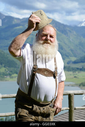 Hotel Gasthof Brüggler Fritz homme barbu en pantalons de cuir et une chemise traditionnelle dans son jardin haut au-dessus de la ville de Zell am See en Autriche le 15 juin 2016. Avec sa barbe Garibaldi il a été vice-Champion d'Europe, Champion du Monde et même barbe Olympia gagnant. Le 06 août 2016, il sera à la 2ème du championnat autrichien internationale des barbus dans le cadre de la 34e fête du village à Dorfgastein. En 2012, il a été attribué pour la plus belle barbe Garibaldi de l'univers. Hotel Gasthof Brüggler Fritz dirige son propre petit musée de couture avec plus de 2500 machines à coudre et de 1000 verres et il prépare sa Banque D'Images