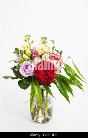 Bouquet de fleurs mixtes de l'Australie et les feuilles dans un bocal en verre Banque D'Images