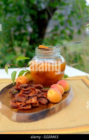 Confiture d'abricot avec un abricotier sur un arrière-plan. Banque D'Images