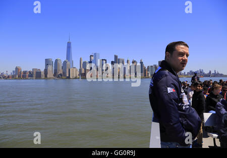 Les passagers de la Statue Cruises dans Upper New York Bay à Liberty Island avec le bas Manhattan skyline à l'arrière.New York,USA Banque D'Images