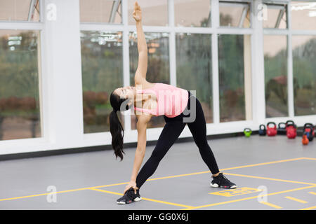 Jeune chinois woman practicing yoga at gym Banque D'Images