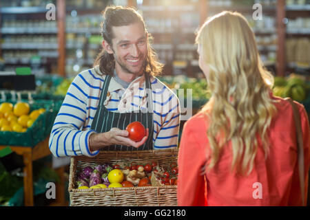 Le personnel masculin assisting woman dans la sélection de légumes frais Banque D'Images