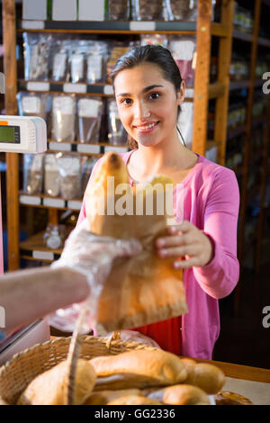 Donner du pain à un paquet personnel femme Banque D'Images