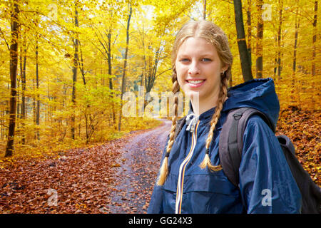 Jeune femme en randonnée dans une forêt d'automne Banque D'Images