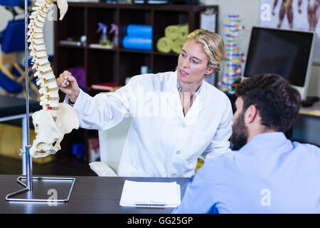 Physiothérapeute expliquant au patient modèle rachis Banque D'Images