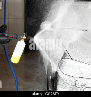 Laver le travailleur de la voiture sous une haute pression. Service de voiture. Banque D'Images